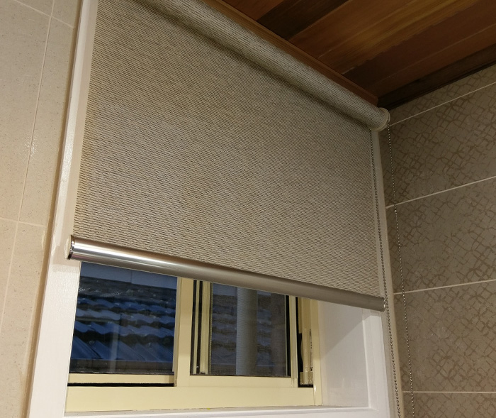 textured light filtering roller blinds installed in a bathroom window
